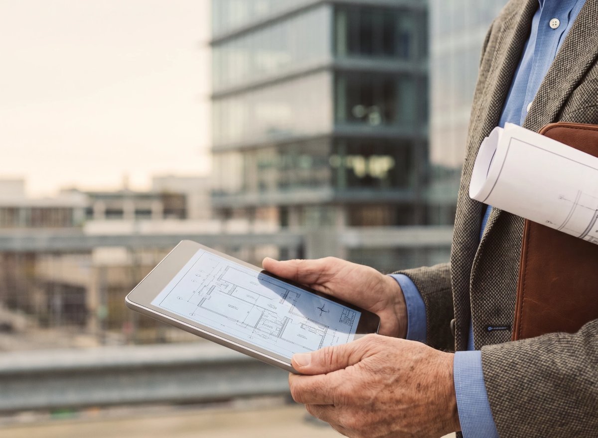 Surveyor reviewing plans on a tablet